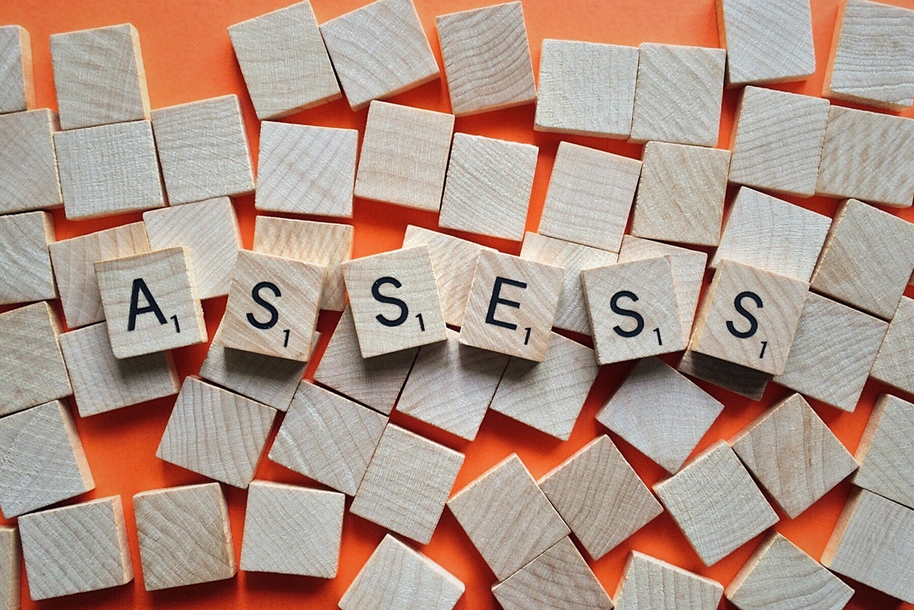 Scrabble tiles spelling out assess